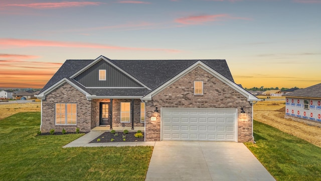 view of front of property featuring board and batten siding, driveway, roof with shingles, a lawn, and brick siding