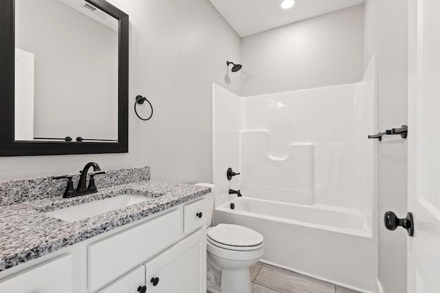 bathroom featuring toilet, tub / shower combination, and vanity