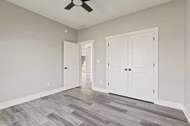 unfurnished bedroom with a ceiling fan, visible vents, baseboards, a closet, and light wood finished floors