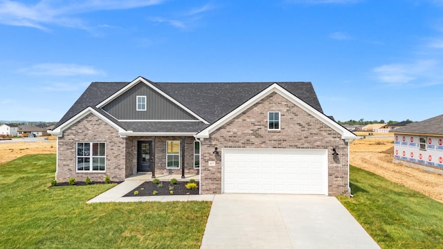 craftsman house featuring board and batten siding, a front yard, driveway, and brick siding
