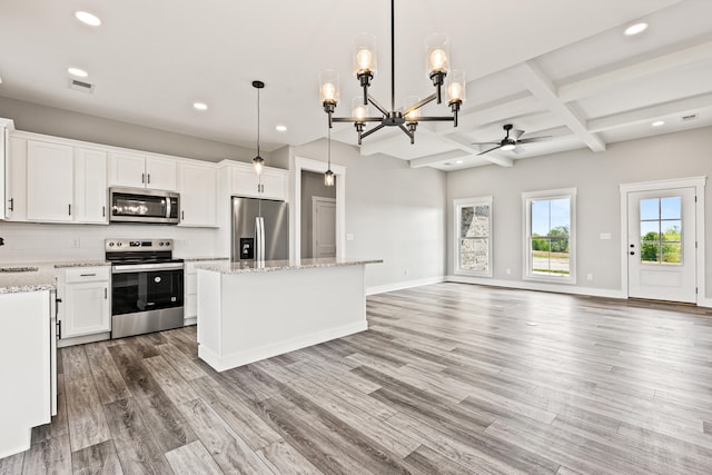 kitchen featuring ceiling fan with notable chandelier, stainless steel appliances, open floor plan, recessed lighting, and a kitchen island