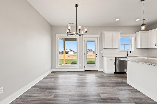 kitchen with an inviting chandelier, recessed lighting, white cabinets, light stone counters, and dishwasher