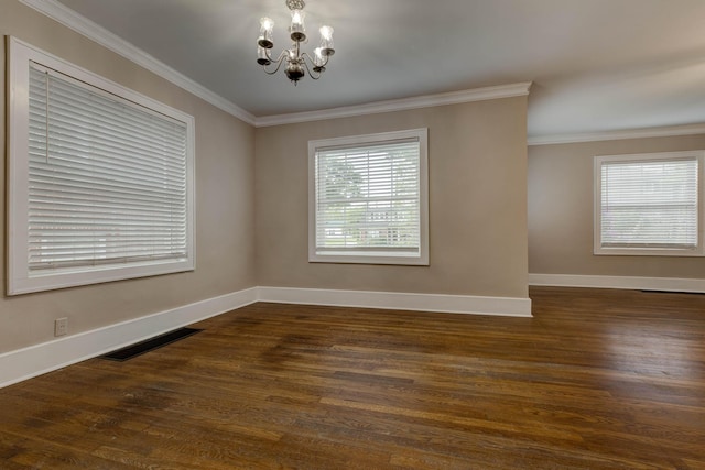 empty room with a chandelier, baseboards, ornamental molding, and dark wood finished floors