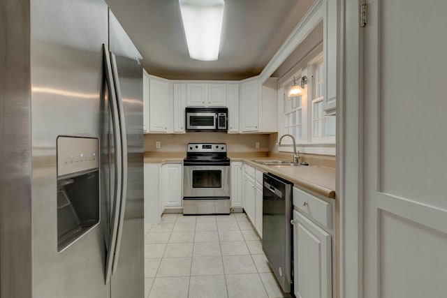 kitchen featuring stainless steel appliances, a sink, light countertops, and light tile patterned floors