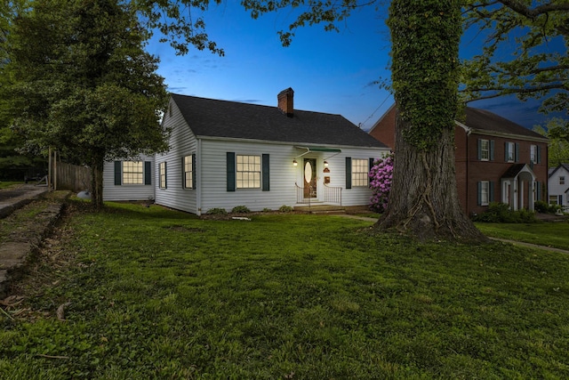 view of front of house featuring a chimney and a shingled roof