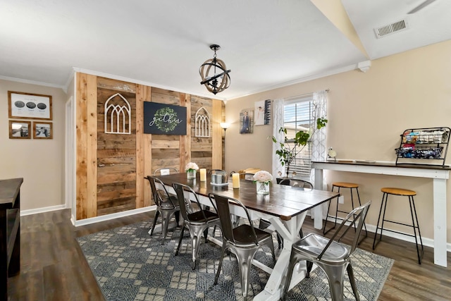 dining space featuring crown molding, wood finished floors, and baseboards