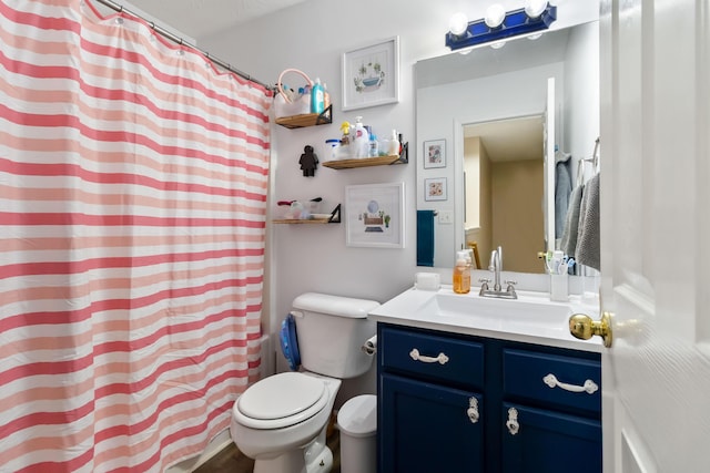 bathroom with toilet, vanity, and curtained shower