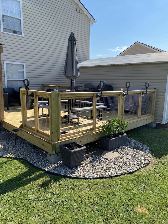 rear view of property featuring a deck and a lawn