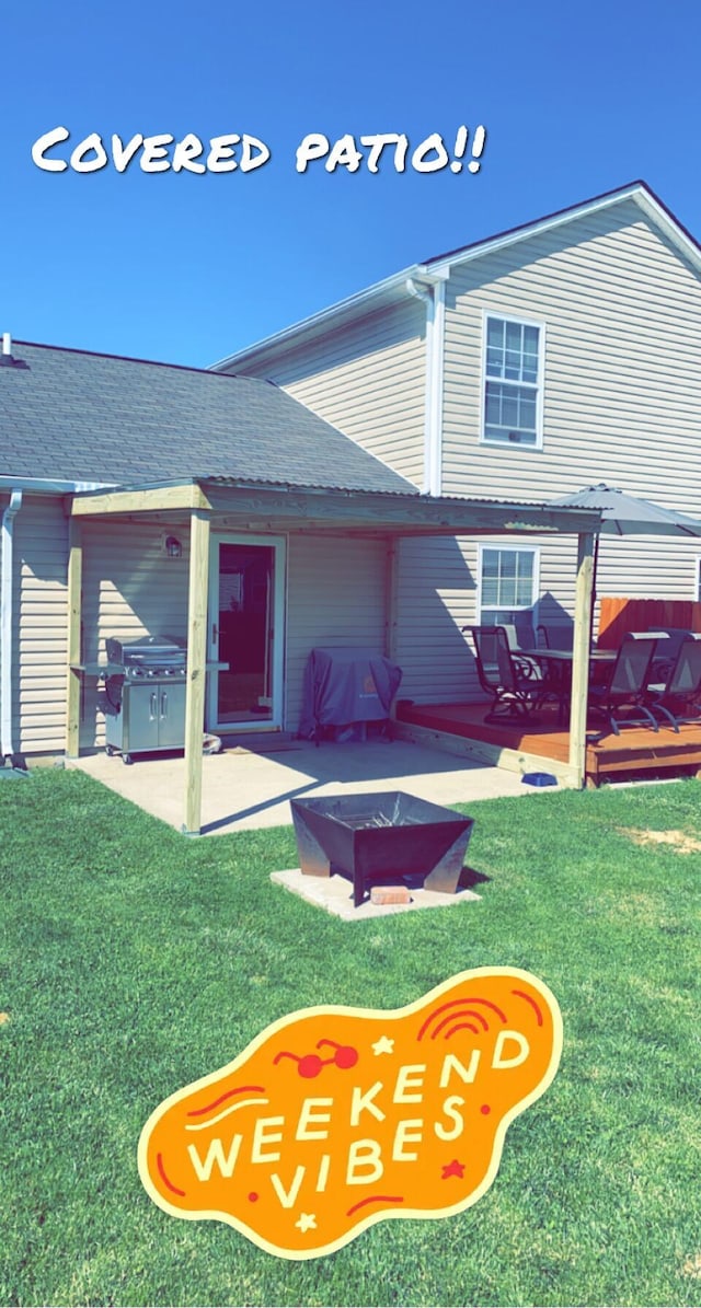 back of house featuring an outdoor fire pit, a lawn, and a patio