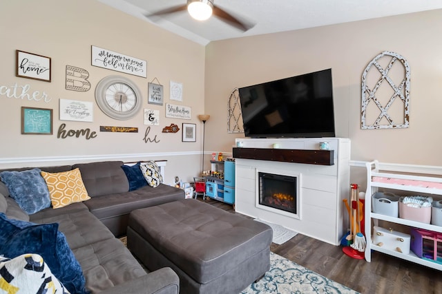 living room with wood finished floors, a ceiling fan, and a fireplace