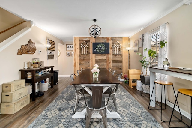 dining space featuring crown molding, wood finished floors, and a chandelier