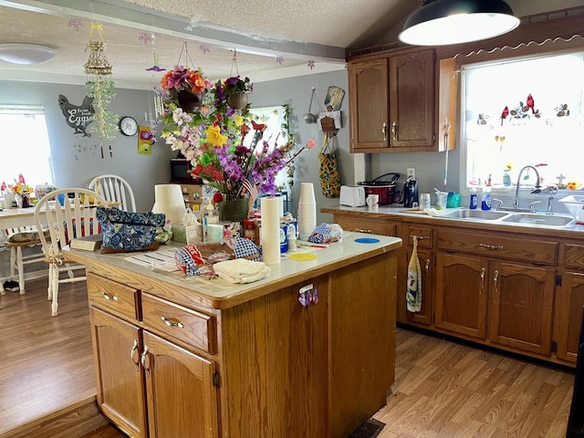 130 Branch Rd, Monticello, KY 42633 - kitchen with a kitchen island, light wood-type flooring, light countertops, a textured ceiling, and a sink