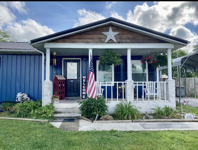 view of front of home featuring a porch, fence, and metal roof