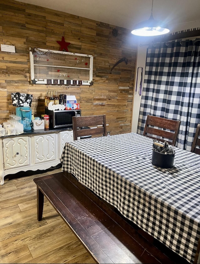 bedroom featuring wooden walls and wood finished floors