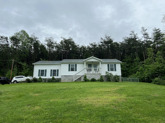 manufactured / mobile home with a view of trees and a front lawn