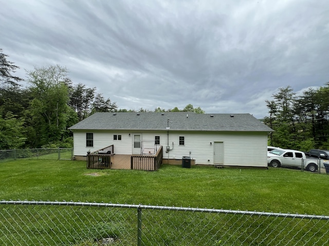 rear view of house featuring a fenced backyard, a yard, central AC, and a deck