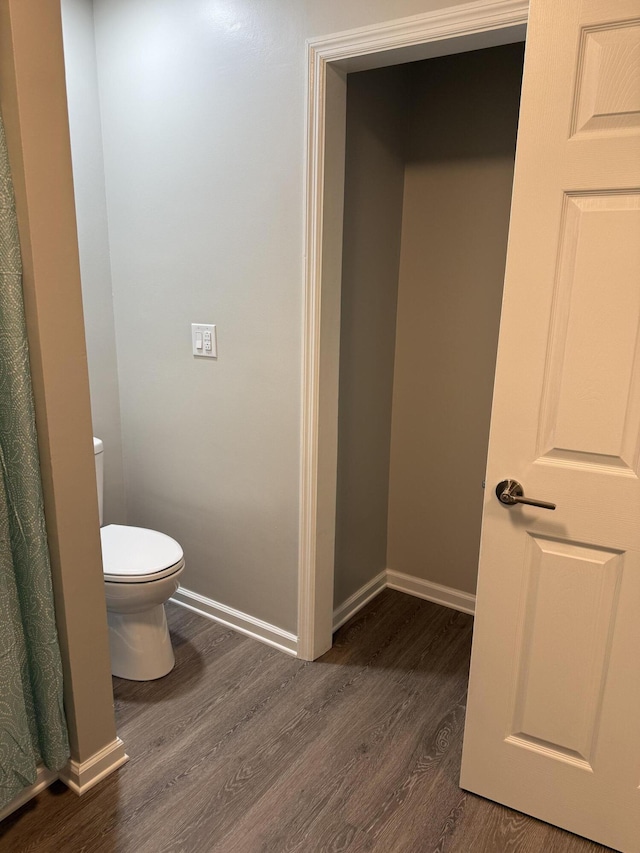 bathroom featuring toilet, baseboards, and wood finished floors
