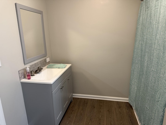 bathroom featuring baseboards, vanity, and wood finished floors