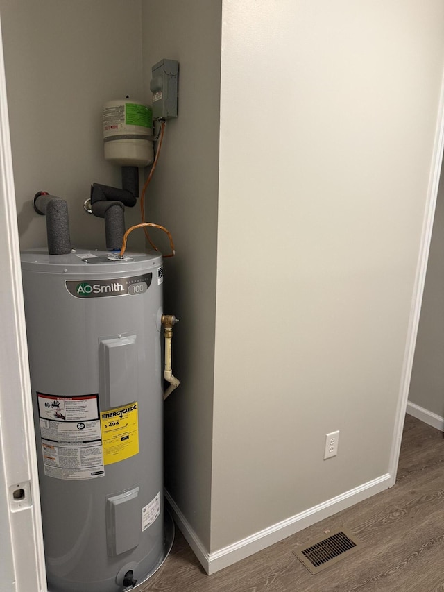 utility room featuring visible vents and electric water heater
