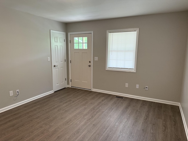 foyer entrance featuring dark wood-style flooring, baseboards, and visible vents