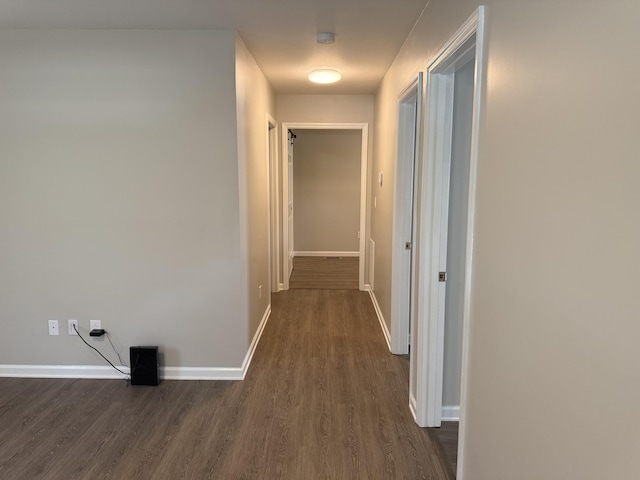 hall with baseboards and dark wood-style floors