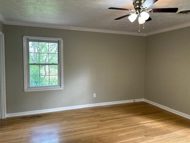 spare room with baseboards, a textured ceiling, light wood-style flooring, and visible vents