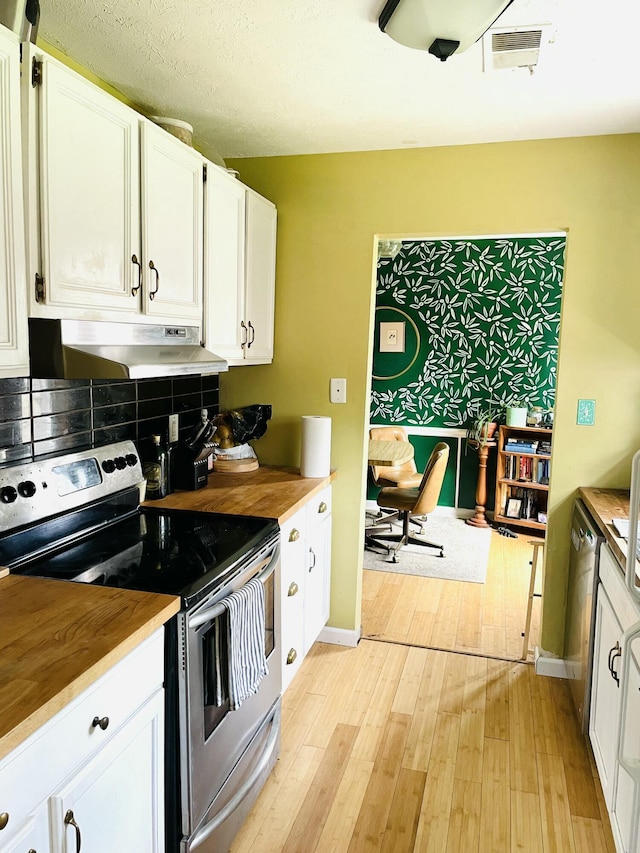 kitchen featuring under cabinet range hood, butcher block counters, light wood-style floors, and appliances with stainless steel finishes