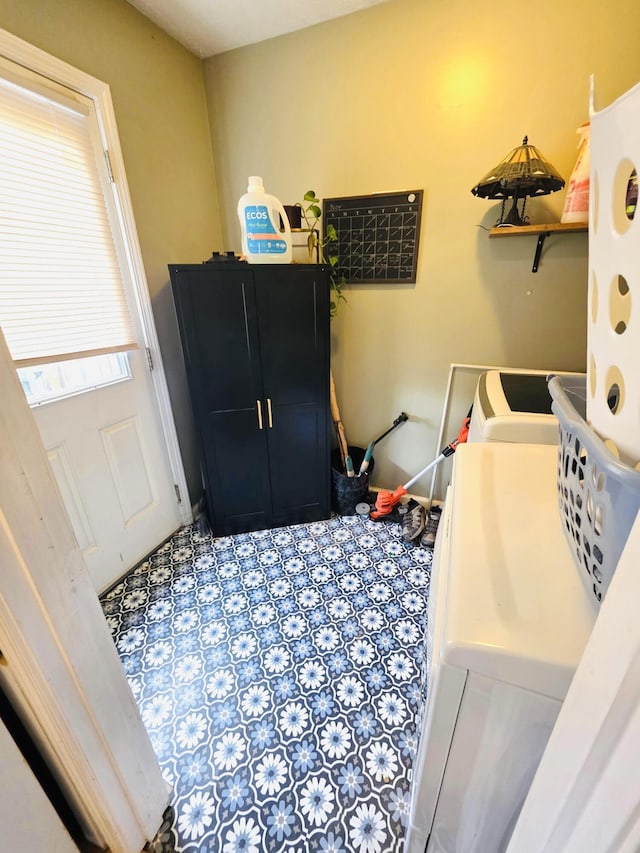 clothes washing area with laundry area, baseboards, tile patterned flooring, and washer / clothes dryer