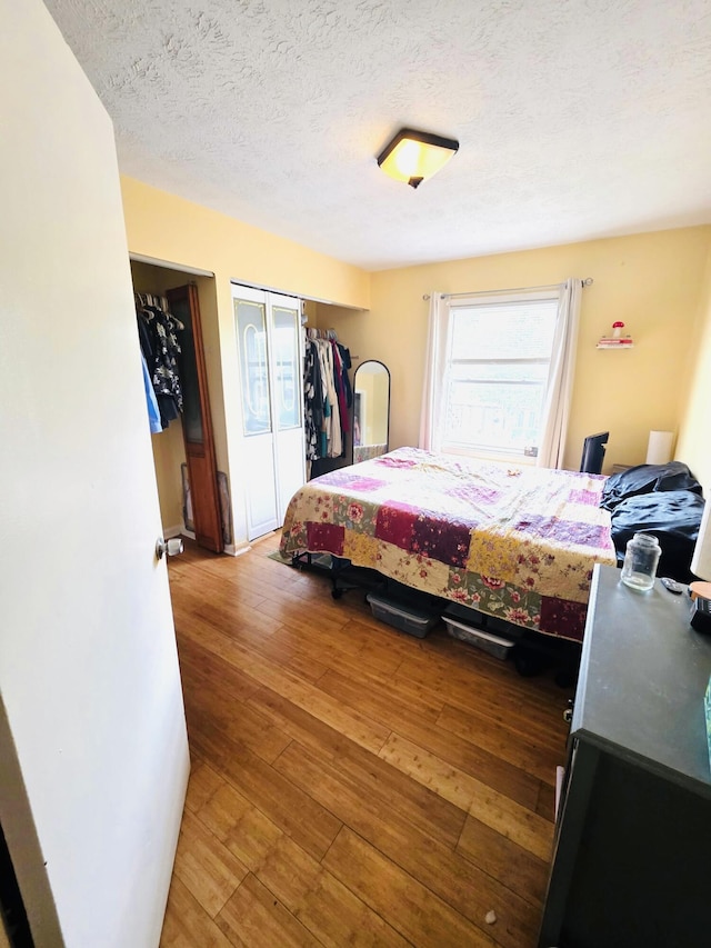 bedroom featuring a textured ceiling, hardwood / wood-style flooring, and a closet