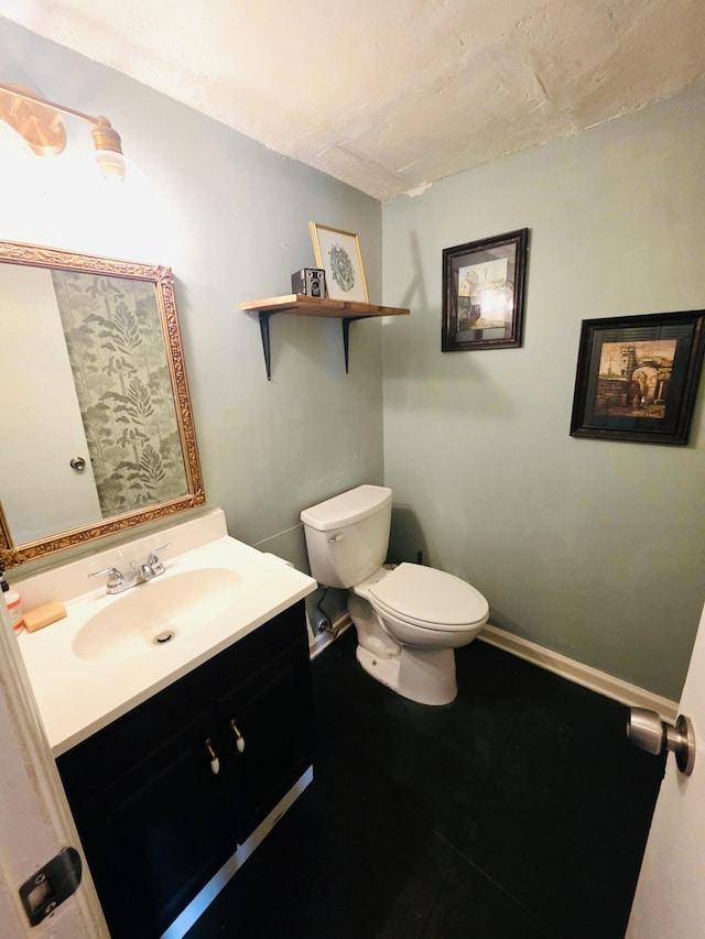 bathroom featuring vanity, baseboards, and toilet