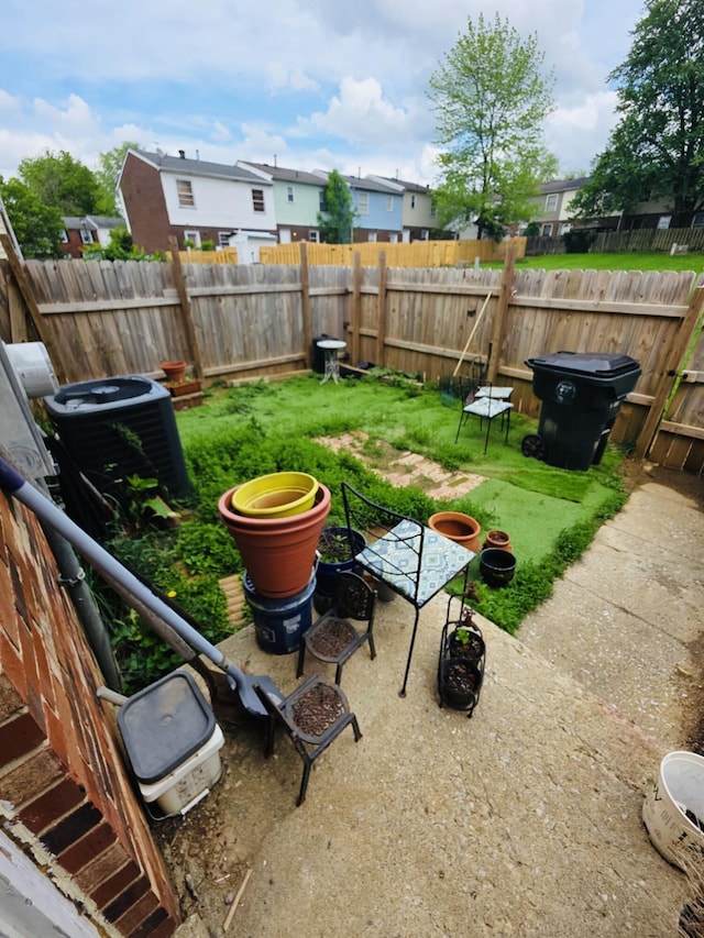 view of yard featuring a fenced backyard, cooling unit, and a residential view