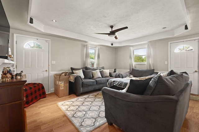 88 Plum St, Stanton, KY 40380 - living area featuring a tray ceiling, plenty of natural light, a ceiling fan, light wood-style floors, and a textured ceiling