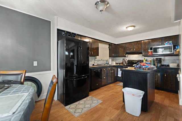 88 Plum St, Stanton, KY 40380 - kitchen featuring black appliances, dark brown cabinetry, light wood-type flooring, under cabinet range hood, and a textured ceiling