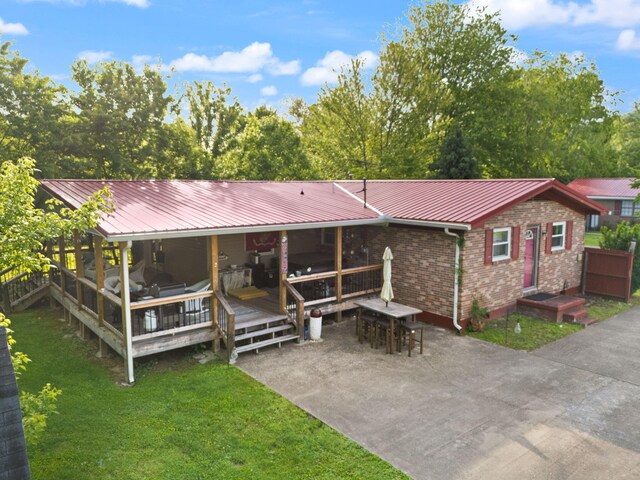88 Plum St, Stanton, KY 40380 - back of house with metal roof, a yard, brick siding, a deck, and a patio