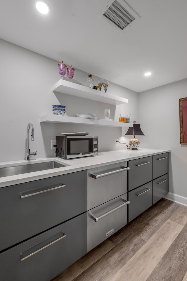 101 Idle Hour Dr Unit 1, Lexington, KY 40502 - kitchen featuring stainless steel microwave, gray cabinets, a sink, wood finished floors, and recessed lighting
