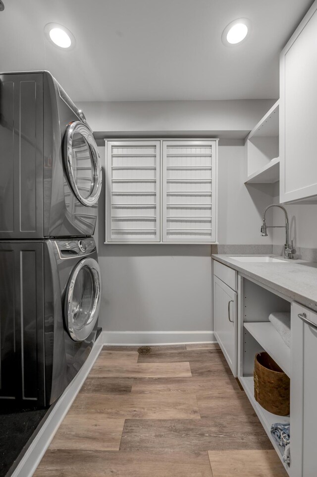 101 Idle Hour Dr Unit 1, Lexington, KY 40502 - laundry room featuring stacked washer / dryer, cabinet space, recessed lighting, baseboards, and light wood-style floors