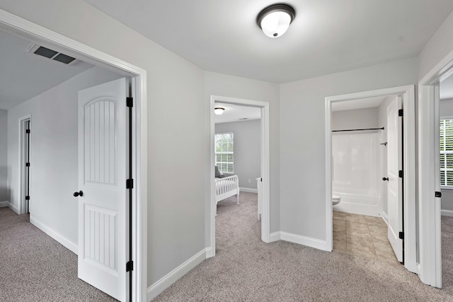 hallway with light carpet and baseboards