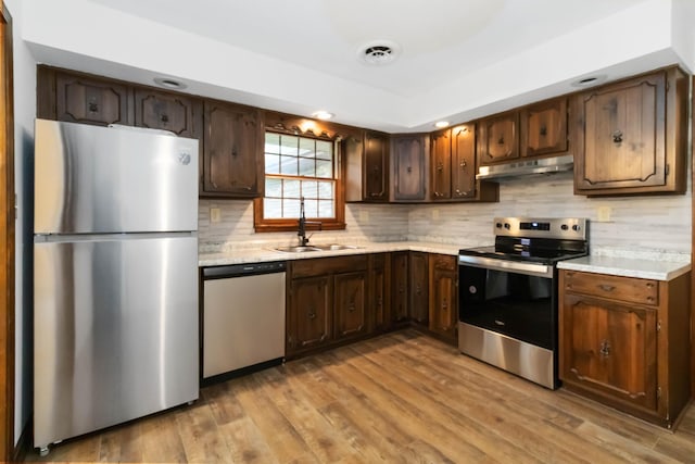 3716 Hickory Hill Dr, Somerset, KY 42503 - kitchen with under cabinet range hood, a sink, backsplash, light countertops, and appliances with stainless steel finishes