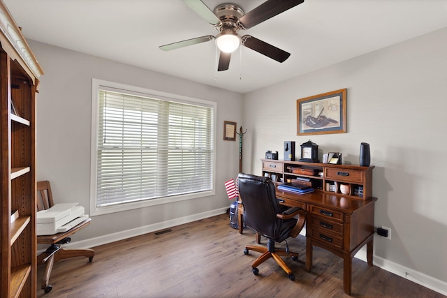 office featuring baseboards, a ceiling fan, visible vents, and wood finished floors
