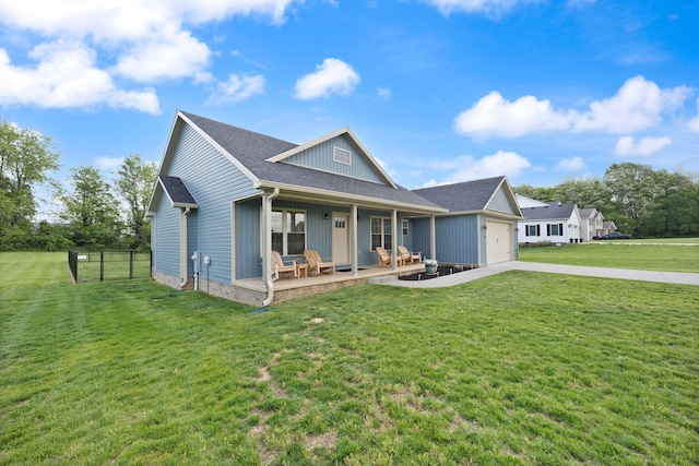 view of front of property with covered porch, a garage, fence, a front yard, and driveway