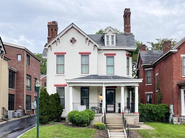 257 S Limestone St Unit 101, Lexington, KY 40508 - view of front of home featuring a porch, brick siding, central air condition unit, a chimney, and a front yard