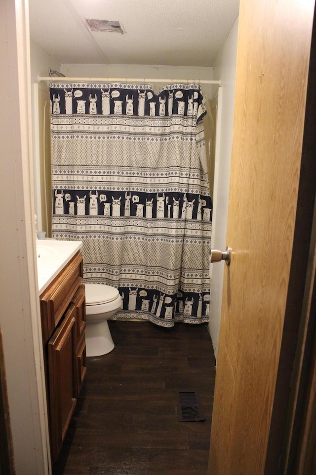 full bathroom featuring toilet, wood finished floors, vanity, curtained shower, and visible vents