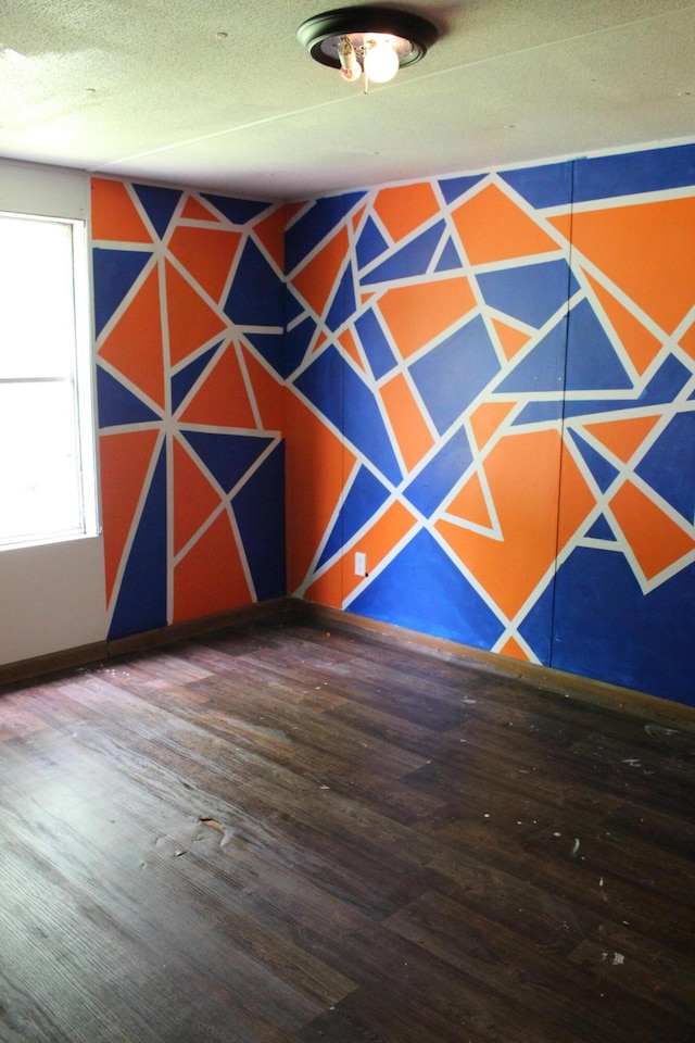 spare room with a textured ceiling and wood finished floors