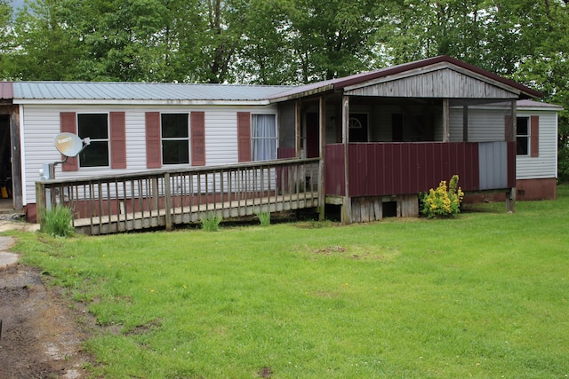 view of front of home featuring metal roof, a front lawn, and a deck