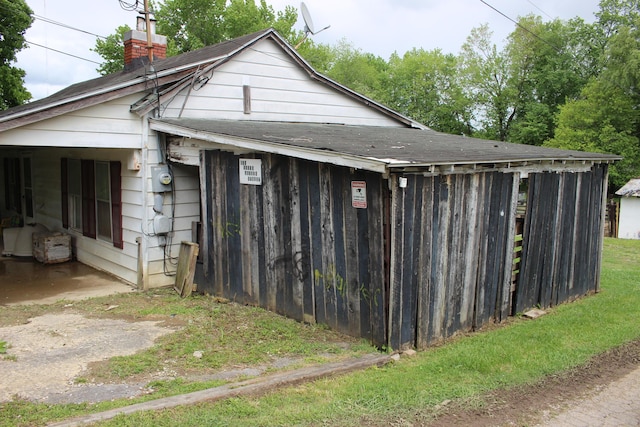 exterior space with roof with shingles and a chimney