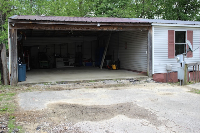 garage with a carport and aphalt driveway