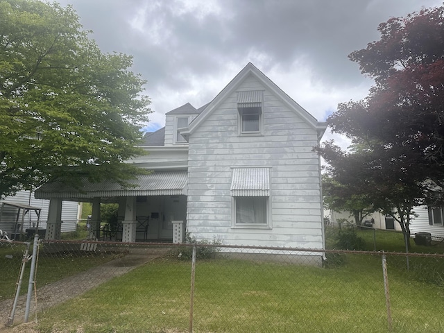 rear view of house featuring a fenced front yard and a yard