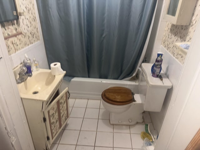 bathroom featuring toilet, tile patterned flooring, shower / bath combo with shower curtain, vanity, and wallpapered walls