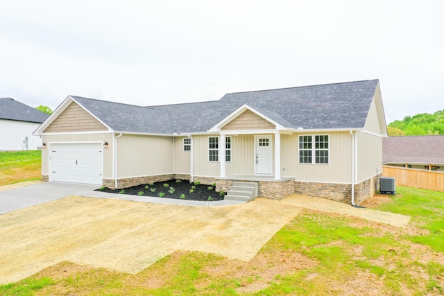 view of front facade with concrete driveway, central AC unit, an attached garage, fence, and covered porch