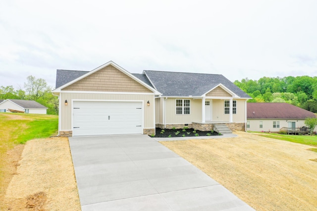 craftsman-style home featuring driveway, an attached garage, a front yard, a porch, and roof with shingles